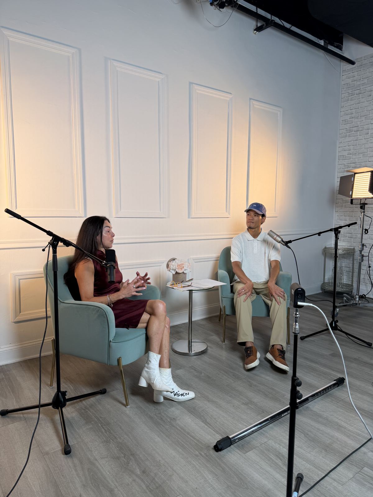 One-on-one interview in mint armchairs with two microphone stands
