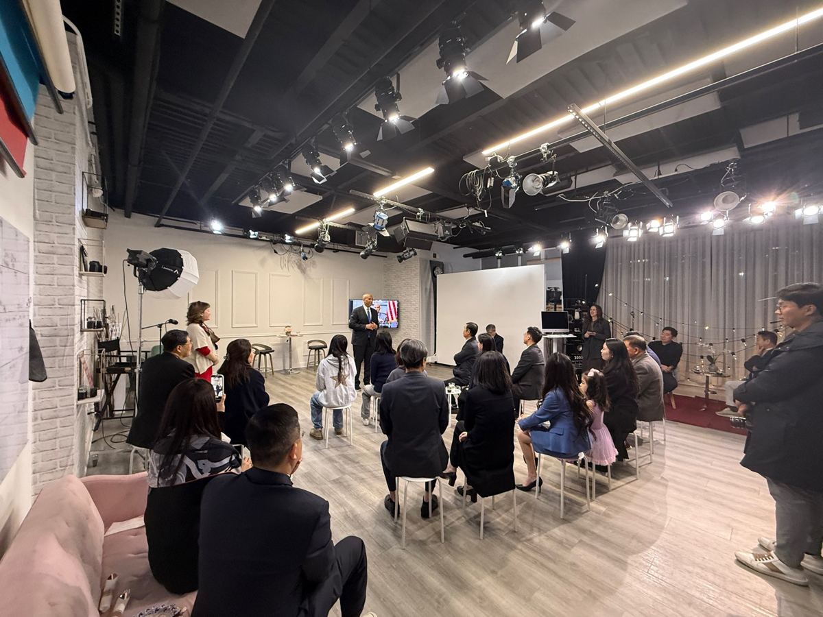 Speaker addressing a full audience under the studio lighting grid
