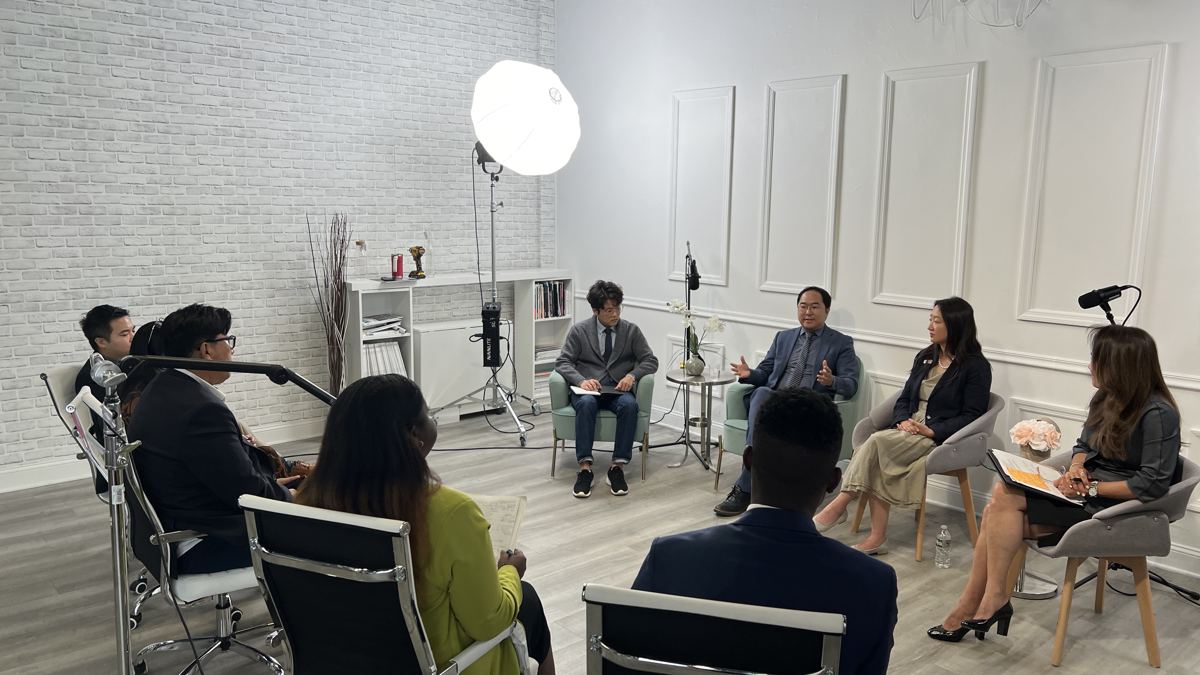 Round table conversation with participants seated in a circle and microphones